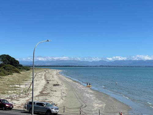 a view of a beach with people in the water at WATERFRONT Home in Nelson
