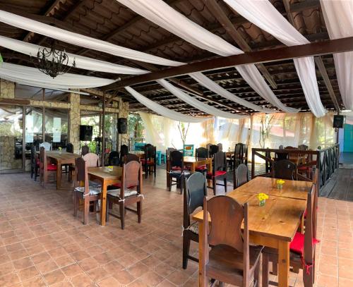 a restaurant with wooden tables and chairs in a room at Stone Cabins Boquete in Boquete