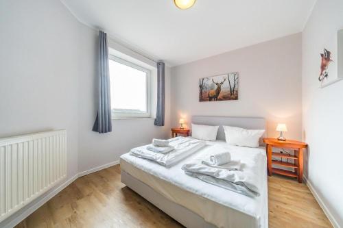 ein Schlafzimmer mit einem weißen Bett und einem Fenster in der Unterkunft Hus Inselkieker Hus Inselkieker 425 in Schillig