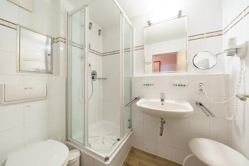 ein weißes Badezimmer mit Dusche und Waschbecken in der Unterkunft Hus Inselkieker Hus Inselkieker 425 in Schillig