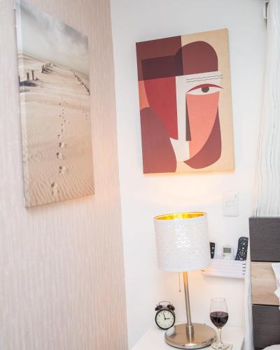 a living room with a lamp and pictures on the wall at Self-checking-Fast internet-Alexa-Smart-Tv-AC-Hot Water in Ensanche Ozama