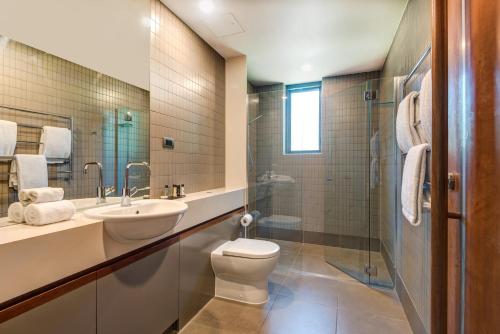 a bathroom with a toilet and a sink and a shower at Yacht Club Villas on Hamilton Island by HIHA in Hamilton Island