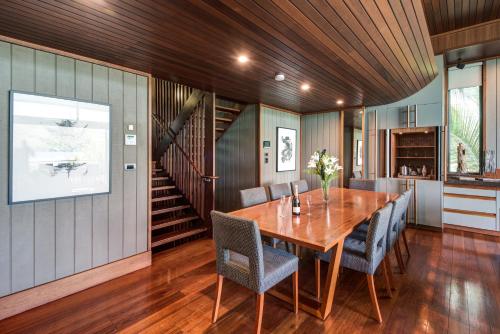 a dining room with a wooden table and chairs at Yacht Club Villas on Hamilton Island by HIHA in Hamilton Island