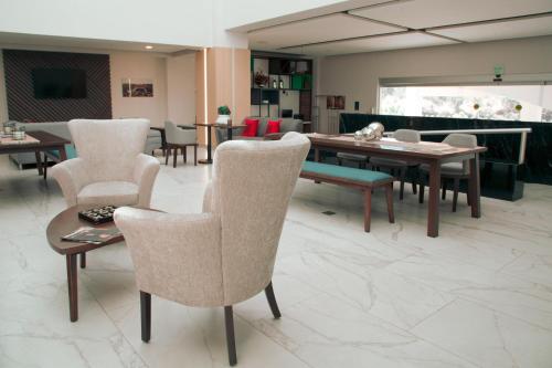 a living room with chairs and a table and a couch at Holiday Inn Tlaxcala by IHG in Tlaxcala de Xicohténcatl