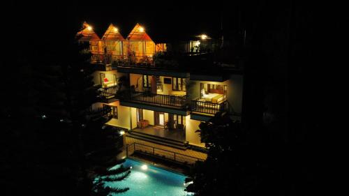 un edificio con piscina di notte di Sceva's Garden Home a Munnar