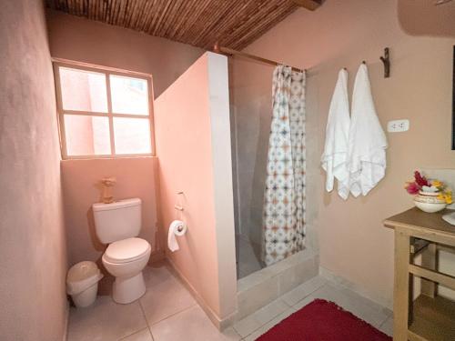 uma casa de banho com um WC e um chuveiro com uma janela em Casa Capirona 1 - Laguna Azul em Tarapoto