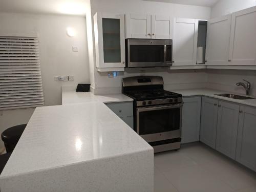 a kitchen with white cabinets and a stove top oven at Joy Estate Rooftop Pool n View unit #1 in Falmouth