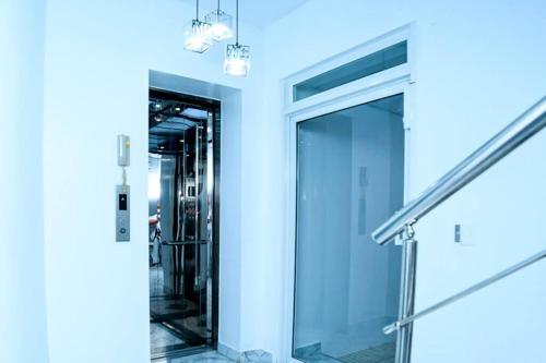 a glass elevator in a building with blue walls at Self-checking-Fast internet-Alexa-Smart-Tv-AC-Hot Water in Ensanche Ozama
