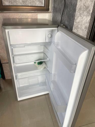 an empty refrigerator with its door open in a kitchen at Homestay Aiyu - Luxury Stay in Shah Alam