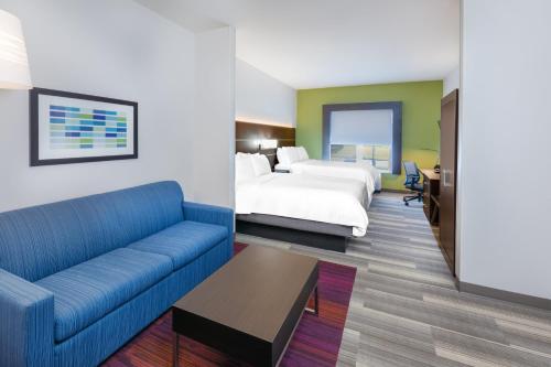 a hotel room with a couch and a bed at Holiday Inn Express Hotel & Suites Picayune by IHG in Picayune