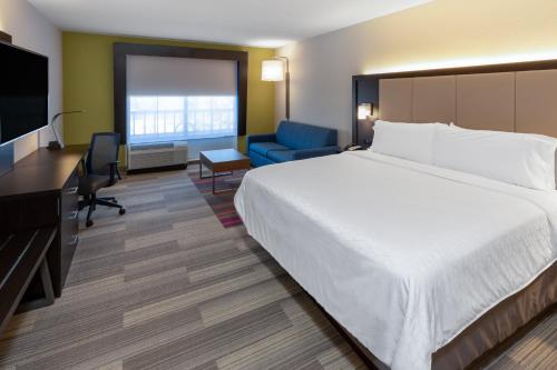 a hotel room with a bed and a desk and a television at Holiday Inn Express Minden by IHG in Minden