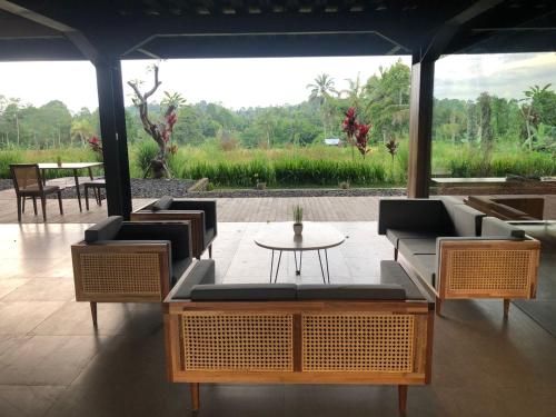 a patio with couches and a table with a view at Teras Hotel Ijen Banyuwangi in Banyuwangi
