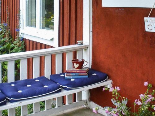 a porch bench with a blue pillow and books at 3 person holiday home in Tystberga in Tystberga