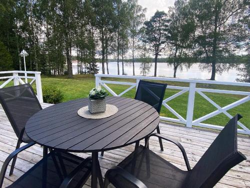 a wooden table and chairs on a deck with a fence at 4 person holiday home in GISLAVED in Gislaved