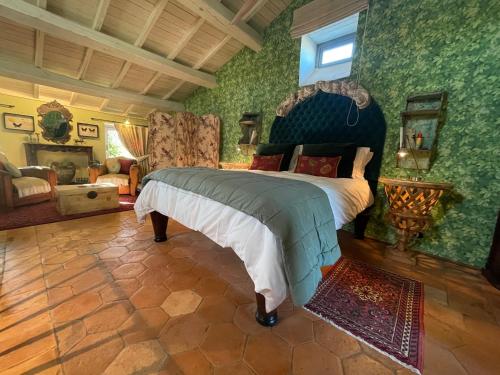 een slaapkamer met een groot bed in een kamer met groene muren bij Flaminivs - luxury in Civita di Bagnoregio in Bagnoregio