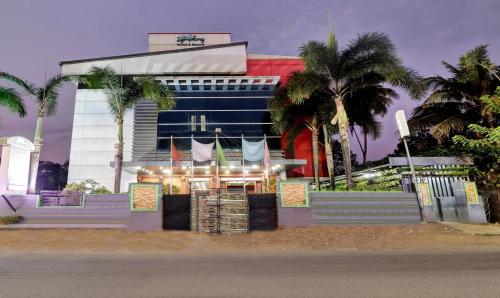 a building with palm trees in front of it at Treebo Symphony Hotels And Resorts Angamally in Kizhake Chālakudi