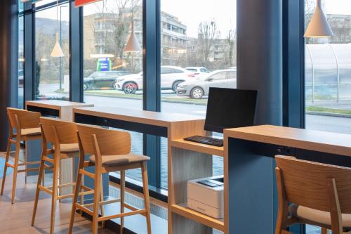a bar with chairs and a computer on a desk at Holiday Inn Express - Aarburg - Oftringen by IHG in Oftringen
