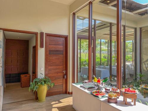 a kitchen with glass doors and a table with food at Fusion Resort Cam Ranh - All Spa Inclusive in Cam Ranh