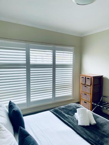 a bedroom with a bed and a large window at The Astor Hotel Motel in Goulburn