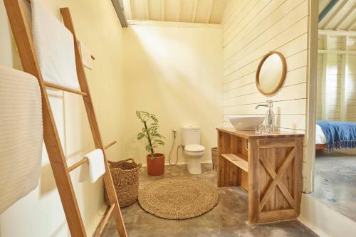 uma casa de banho com um lavatório, um WC e um espelho. em House of Sawah em Batukaras
