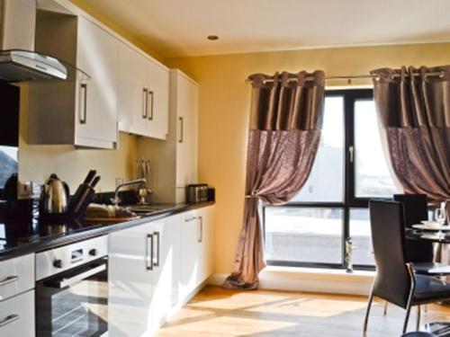 
a kitchen with a sink, stove and a window at The Penthouse- The Kingsley Collection in Troon
