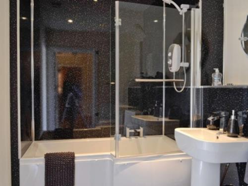 a bathroom with a glass shower and a sink at The Penthouse- The Kingsley Collection in Troon