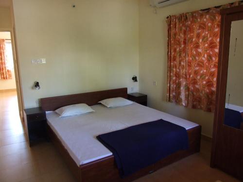 ein Schlafzimmer mit einem Bett und einem großen Fenster in der Unterkunft Empire Guest House in Calangute