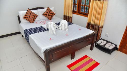 a bedroom with a bed with towel animals on it at The King's Garden Resort in Dambulla