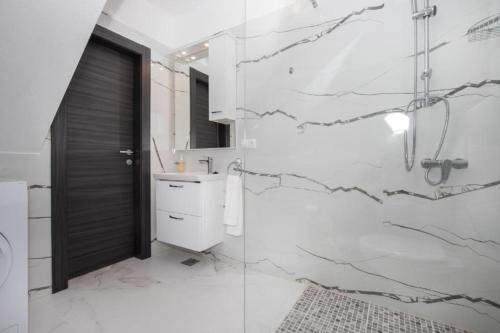 a bathroom with a shower and a toilet and a sink at Apartments Jakov - modern and cosy with pool in Postira