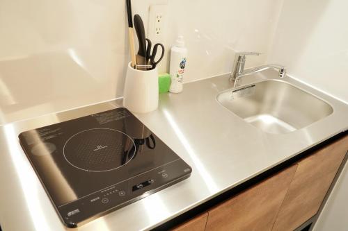 a kitchen counter with a sink and a stove at Liaison Court Nishikujo Universal Bay in Osaka