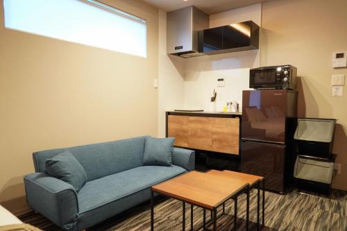 a living room with a blue couch and a kitchen at Liaison Court Nishikujo Universal Bay in Osaka