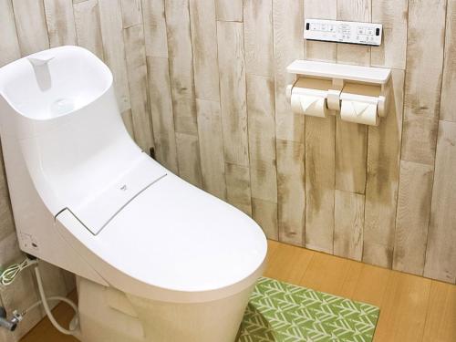 a white toilet in a bathroom with a shower at Calm house Beppukitahama in Beppu