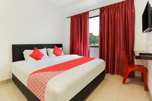 a bedroom with a bed with red curtains and a window at Super OYO 89495 Rich Hotel in Johor Bahru