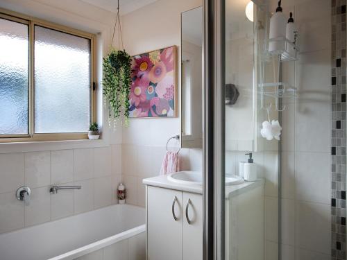 bagno con vasca, lavandino e doccia di Wayfarer Cottage a Daylesford