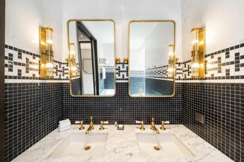 a bathroom with two sinks and two mirrors at Hotel Crescendo Seoul in Seoul