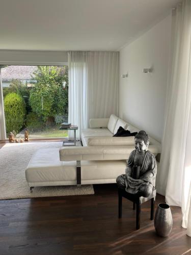 陶努斯泰因的住宿－Gemütliche Villa am Waldrand in Taunusstein，卧室,有男人坐在椅子上的雕像