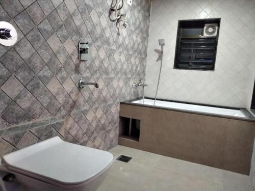 a bathroom with a toilet and a sink and a mirror at Sun Inn Residency in Mumbai