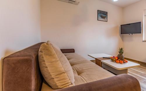 a living room with a couch and a tv at Medulinka apartments in Medulin