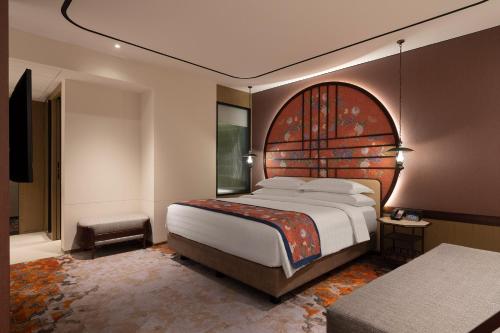 a bedroom with a large bed with a wooden headboard at Episode Gading Serpong in Tangerang