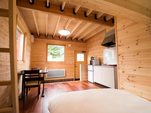 a bedroom with a bed and a table in a room at Brick House Furano in Furano