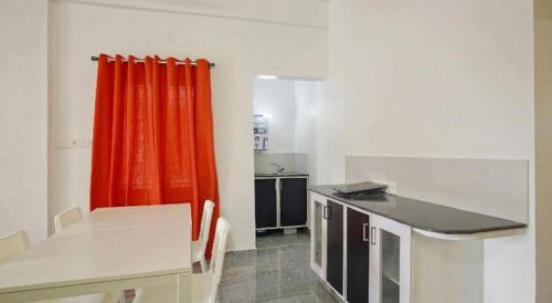 a kitchen with an orange curtain in a room at Retaj Residency in Ernakulam