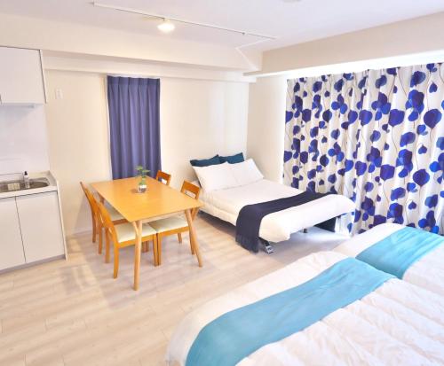 a room with two beds and a table and a kitchen at Fuchsia - Vacation STAY 29048v in Nagoya