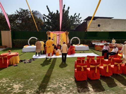a group of people standing around a stage with red chairs at Hotel Maiden Residency in Ghaziabad