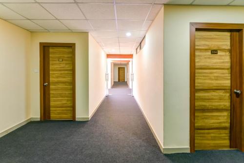 an empty corridor in an office building with wooden doors at Mount Amara Hotel & Spa, Siliguri in Siliguri