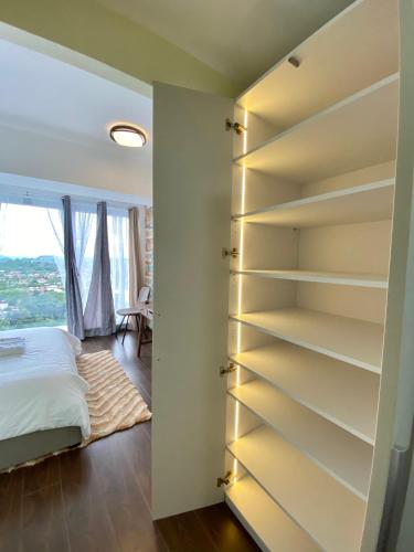 a bedroom with a book shelf next to a bed at Condotel Aeon Towers Davao 20mbps Wifi in Davao City
