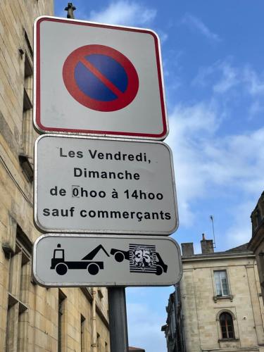 a no parking sign on a pole in front of a building at T2 hypercentre Libourne 5 min St Emillon in Libourne