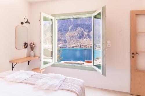 a bedroom with a window with a view of the ocean at Petra Boutique Villas in Aryinónda