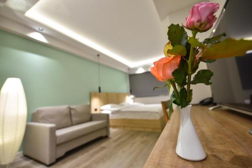 a vase with flowers on a table in a room at Baron Boutique Hotel Yerevan in Yerevan
