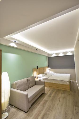 a bedroom with two beds and a couch in a room at Baron Boutique Hotel Yerevan in Yerevan