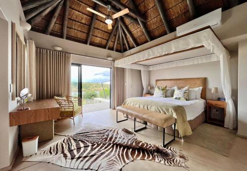 sypialnia z dużym łóżkiem i dywanem zebra w obiekcie Jacana River Lodge Mjejane Game Reserve w mieście Hectorspruit